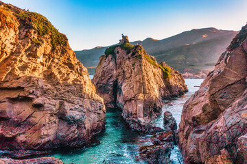 Narrow ocean channel surrounded by rugged cliffs at Garrapata State Park Bluff Trail along Highway...