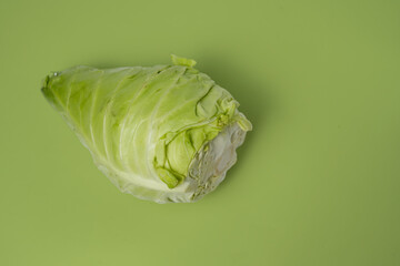 Fresh Green Cabbage on Vibrant Green Background Showcasing Raw Vegetables