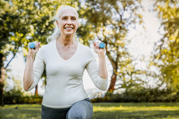 Close up shot of senior woman retired person enjoys workout, exercises with dumbbell, training body...