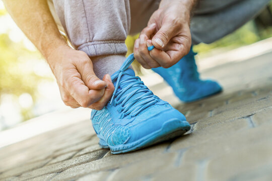 Senior man, tie shoelace and running, fitness and cardio in the park, start and health, wellness and vitality. Runner is ready for exercise, athlete and sports with sneakers, path outdoor and active