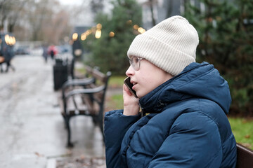 Teenager Girl Walking Alone on City Street with Smartphone. Portrait of 14 years old girl wearing...