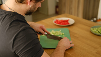 Man preparing fresh vegetables in modern kitchen, organic ingredients. Healthy meal. Cooking Food...