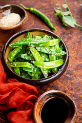 Asian food stir fried green peas with sesame seeds vertical photo