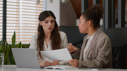 Multiracial businesswomen African American Caucasian girls displeased coworkers office company...