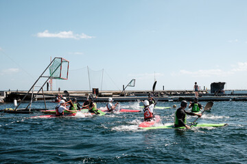 Kayakers Competing in a Canoe Polo Match on a Sunny Day at the Harbor.