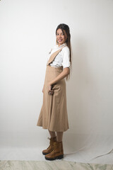 Elegant Female Model in Beige Designer Dress Against Minimal White Background