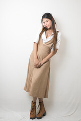Elegant Female Model in Beige Designer Dress Against Minimal White Background