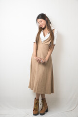 Elegant Female Model in Beige Designer Dress Against Minimal White Background