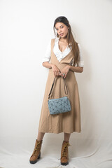 Elegant Female Model in Beige Designer Dress Against Minimal White Background