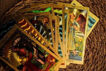 Tarot cards with gold accents lie on burlap. 
