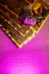 Tarot cards with gold designs of a King and Queen lie on woven fabric. Rock crystal, pyrite, and a...