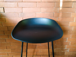 Black chair with red brick textured wall background