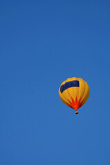 A lonely balloon in the vastness of the blue sky
