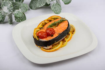 baked salmon fillet with tomatoes and herbs on a white background with decoration