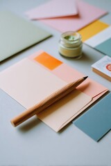 Colorful stationery items including envelopes, paper sheets, and a pencil arranged on a light surface, creating an inviting workspace atmosphere for creative projects