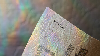Abstract iridescent crumpled paper texture with innovation text; futuristic, technological, and hopeful mood.
