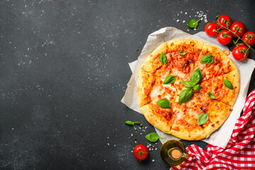 Pizza margarita on black background with ingredients for cooking.