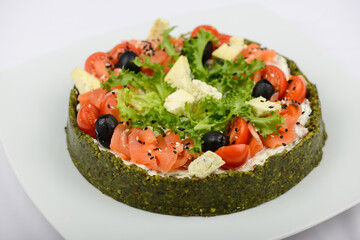 spinach pie with cheese, herbs and tomatoes on a white background