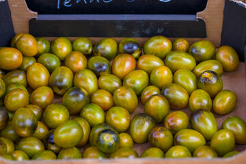 Fresh green cherry tomatoes and vegetables on farmers market stall. Vegetable on the market counter. . High quality photo