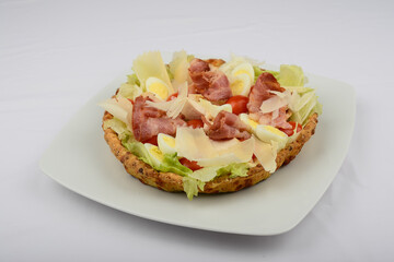 pie with bacon and herbs and tomatoes on a white plate