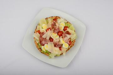 pie with bacon and herbs and tomatoes on a white plate on a white background
