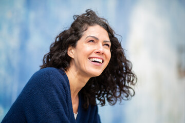 Candid close-up of a cheerful woman in a navy sweater laughing