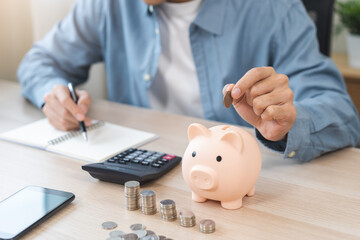 Saving money wealth concept, asian young business man hand putting coin into piggy for saving cost,...