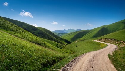 Fototapeta premium serene winding dirt road through lush green hills under a clear blue sky inviting exploration