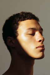 Close-up portrait of a serene young person with closed eyes and dramatic lighting