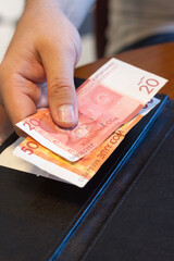 hand holding money to pay the bill at a restaurant