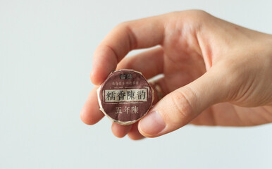 hand holding compressed chinese black tea in a package isolated on white 