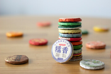a column of chinese tea discs in the center with other tea bricks spread on the table, chinese tea ceremony concept