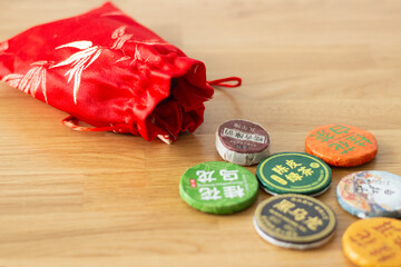 a red bag with different types of traditional chinese tea (compressed), isolated on wooden background