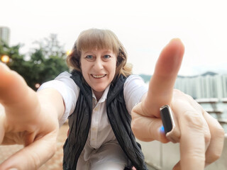 Mature woman enjoys a vibrant selfie while exploring the beautiful streets of Hong Kong during her...