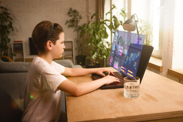 Hologram learning. Young boy focuses on a high-tech interactive digital dashboard while using a...