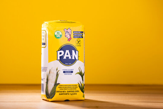 Studio shot of Harina P.A.N. 1kg white corn flour package on a home table and over matching yellow background. Used to prepare traditional Venezuelan arepas.