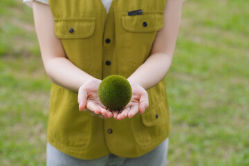 Woman Holding Green Moss Ball Outdoors