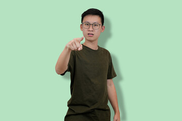 Man Standing with Pointing Gesture on a Light Green Background