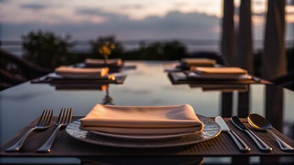 Elegant dining table set for sunset, featuring plates and cutlery, with a serene outdoor ambiance.