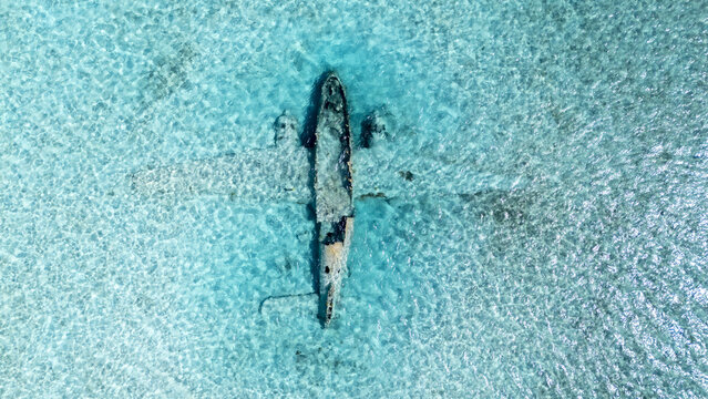 Aerial view of  Pablo Escobar plane sank   in  the turquoise waters, a stark contrast against the clear, rippling sea, Black Point, New providence, The Bahamas.