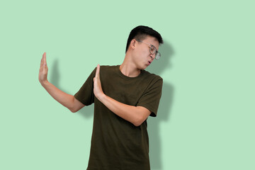 young nerd Man Wearing Glasses Gesturing No Against Green Background