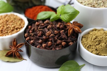 Different aromatic spices on white table, closeup