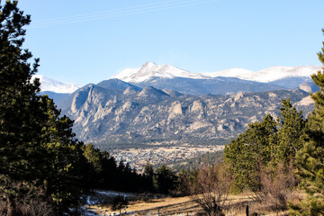 Snow-Capped Mountains and Pine Forest Under a Clear Blue Sky as seen from Peak to Peak highway in...