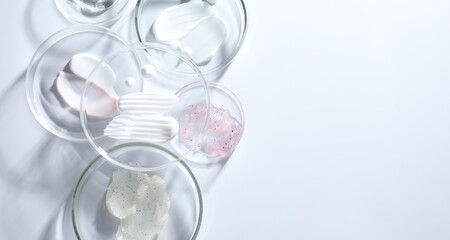 Different cosmetic products in Petri dishes on white background, flat lay. Space for text