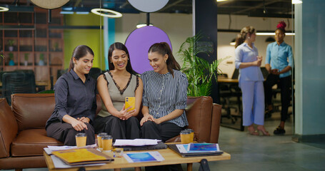 Indian young adult young adult woman lady hold mobile look cam talk gossip on video call at work place happy female girl staff use phone speak distant enjoy break spend time have fun joy job office