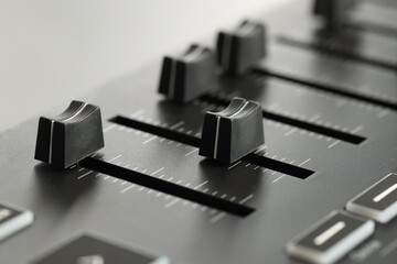 MIDI keyboard with faders on light background, closeup