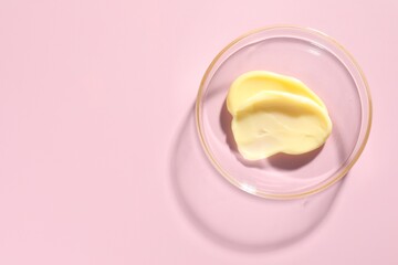 Cosmetic product in Petri dish on pink background, top view. Space for text