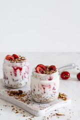 Healthy breakfast yogurt with multigrain granola, cherry,  and chocolate in glass jar