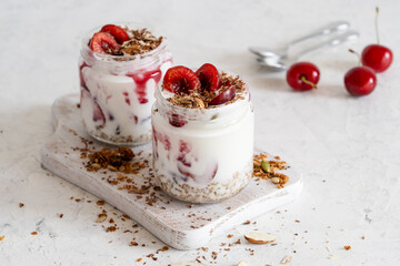 Healthy breakfast yogurt with multigrain granola, cherry,  and chocolate in glass jar
