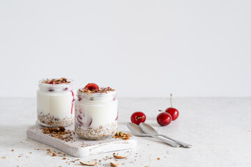 Healthy breakfast yogurt with multigrain granola, cherry,  and chocolate in glass jar